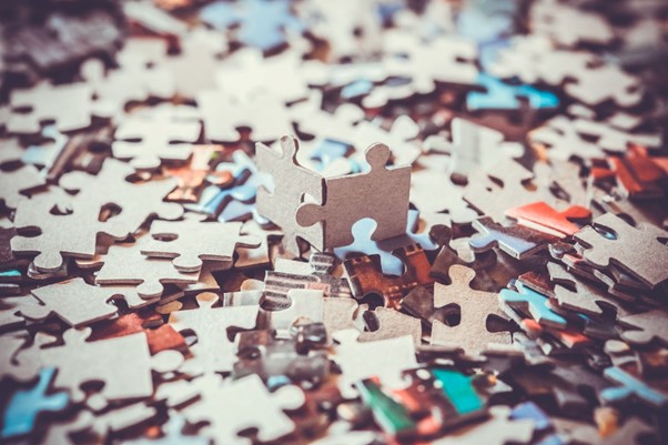 Jigsaw puzzle pieces laid out in a pile on a table.